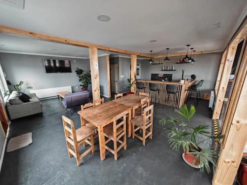 sala de estar con mesa de madera y sillas en SHEUEN PATAGONIA, en Puerto Natales