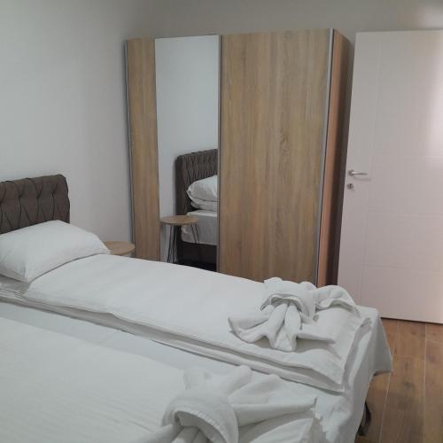a bedroom with a white bed with a mirror at Spa Koncept-Apartmani in Veliko Gradište