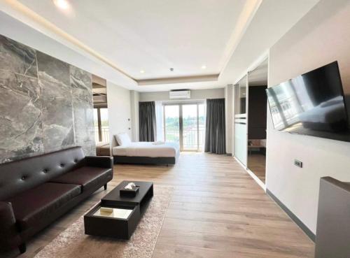 a living room with a couch and a tv at S.R.SUNSHINE HOTEL in Ban Sok Dua