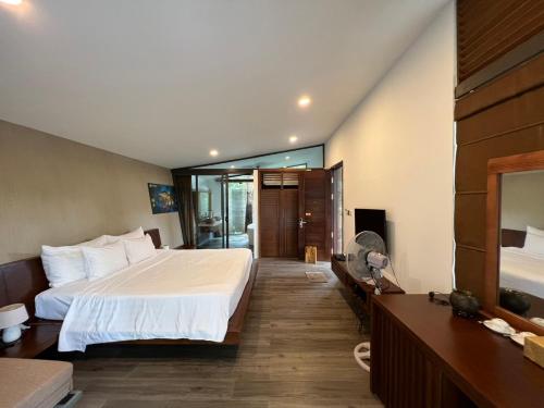1 dormitorio con 1 cama grande y espejo en Forest Villa 329 Flamingo Dai Lai, en Phúc Yên