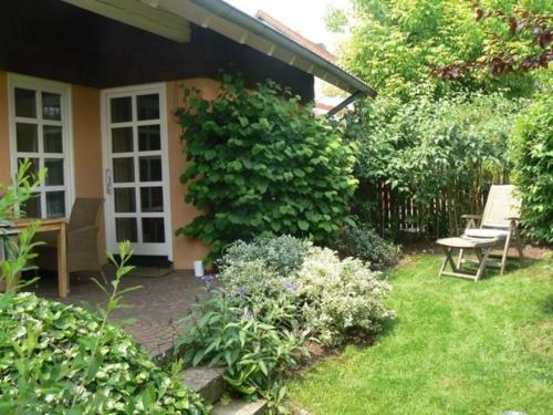 un giardino con panchina e tavolo e una casa di Ferienwohnung Am Odenwaldlimes a Vielbrunn