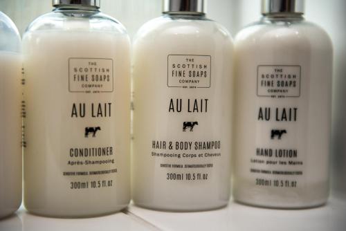 a row of four bottles of milk and flow shampoos at Stag Manor Hot Tub Retreat near Peak District in Crich