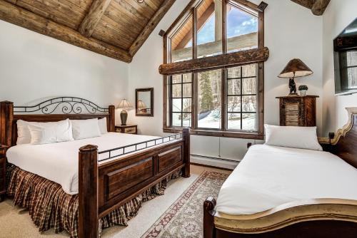 two beds in a bedroom with two windows at Bachelor Gulch Village by Vail Resorts in Avon