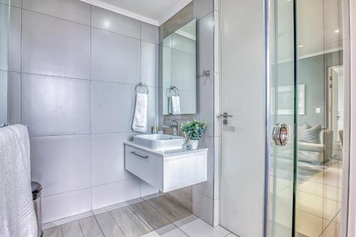 a white bathroom with a sink and a shower at Masingita Towers Premium Hotel in Johannesburg