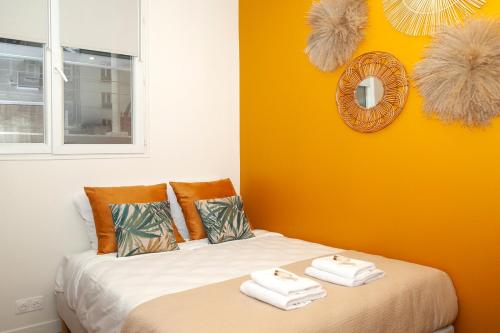 une chambre avec un lit avec des serviettes dessus dans l'établissement Nets Inn Apartments - Buttes Chaumont D, à Paris