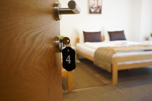 a room with two beds and a door with a number four tag at Apartman - Sobe Tiha Luka, Bjelašnica in Bjelašnica
