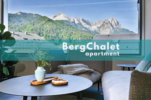 una camera con tavolo e finestra con vista sulle montagne di BergChalet a Garmisch-Partenkirchen