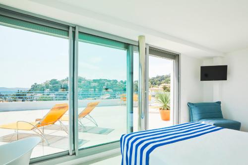 a bedroom with a bed and a balcony at Hôtel California in Le Lavandou