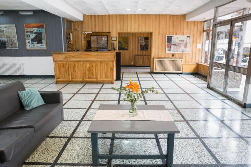Un vestíbulo con un sofá y una mesa con flores. en NBH Premier Hotel, en San Carlos de Bariloche