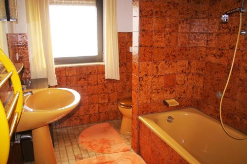 ein Badezimmer mit einer Badewanne, einem WC und einem Waschbecken in der Unterkunft Ferienwohnung Schaefer in Michelstadt