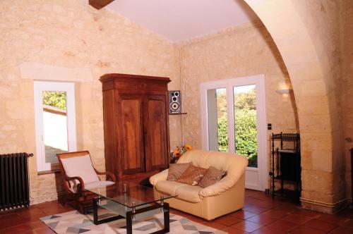 a living room with a couch and a table at La Métairie près de Bordeaux in Haux