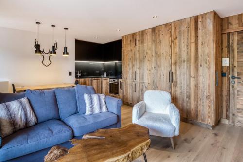 a living room with a blue couch and a chair at Warm apartment nestled in the heart of Megeve in Megève
