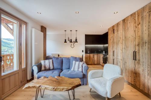 un salon avec un canapé bleu et une chaise dans l'établissement Appartement 2 chambres en centre-ville de Megève, à Megève