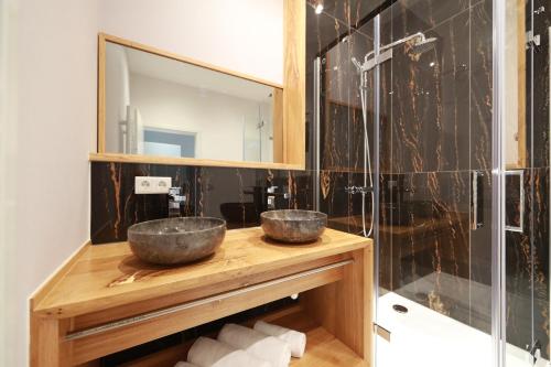 a bathroom with two bowls on a wooden counter with a mirror at 36 Phô Cô Hotel & Suites in Weimar