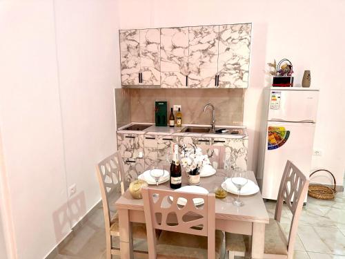 a kitchen with a table and chairs and a refrigerator at Shell Home golem 1 in Golem