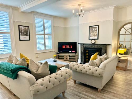 a living room with two couches and a fireplace at Gillygate Nest with Free Allocated Parking in York