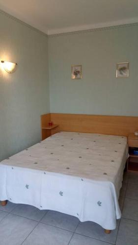 une chambre avec un lit blanc dans une pièce dans l'établissement T3 tout confort en front de mer, clim, à Saint-Cyprien