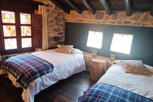 1 dormitorio con 2 camas y 2 ventanas en Casa Rural con encanto en plena Reserva de Urbión., en Vinuesa