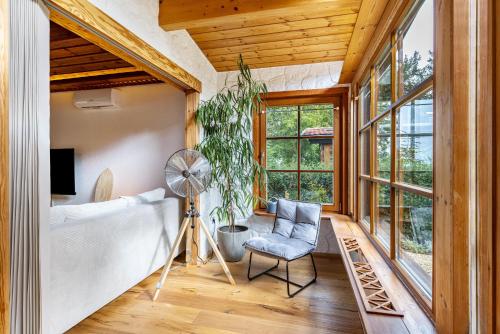 Zimmer mit einem Bett, einem Ventilator und einem Stuhl in der Unterkunft La Casa Holzwiesen in Starzach