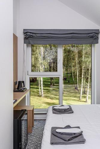 ein Schlafzimmer mit einem Bett, auf dem zwei Handtücher liegen in der Unterkunft Molėtairesort in Molėtai