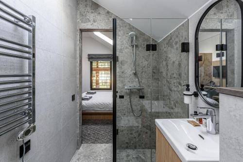 ein Bad mit einer Dusche und einem Waschbecken in der Unterkunft Molėtairesort in Molėtai