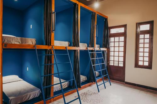 a group of bunk beds in a room with blue walls at Hostel Casarão Fronteira in Santana do Livramento
