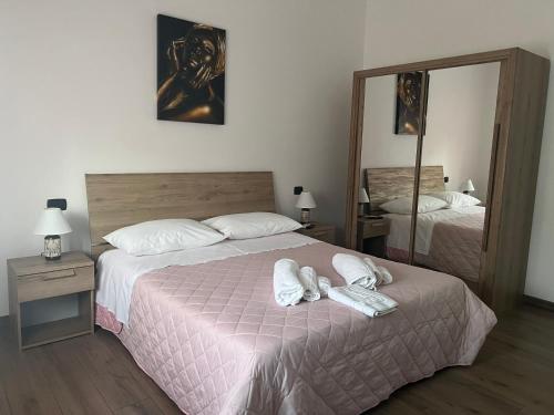 a bedroom with two beds and a mirror at Stanza Georgina in Verona
