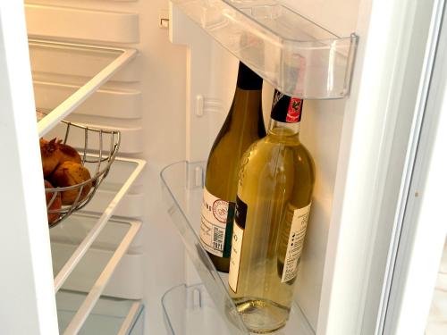 two bottles of wine in an open refrigerator at Shell Home golem 1 in Golem