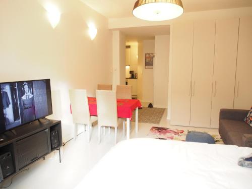 a living room with a dining table and a television at Top Apartments Helsinki - Alppila in Helsinki
