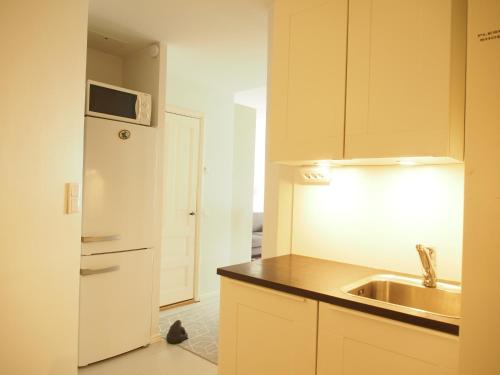 a kitchen with a sink and a white refrigerator at Top Apartments Helsinki - Alppila in Helsinki