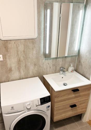 a laundry room with a washing machine and a sink at Tromsdalen Aurora Apartments in Tromsø