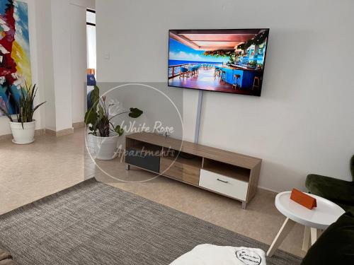 ein Wohnzimmer mit einem Flachbild-TV an der Wand in der Unterkunft WhiteRose Apartments in Meru