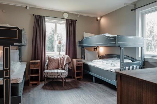 a bedroom with two bunk beds and a chair at Trillevallens Högfjällshotell & Lägenheter in Trillevallen
