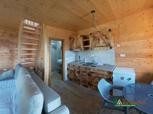 una sala de estar con sofá y lavamanos en una cabaña de madera en Brvnare Kušići, en Ivanjica