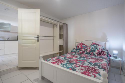 een slaapkamer met een bed met een bloemenbed bij Heliconia - Appt avec piscine partagée in Saint-Pierre