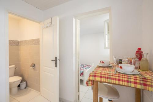 ein Bad mit einem Tisch, einem Waschbecken und einem WC in der Unterkunft Heliconia - Appt avec piscine partagée in Saint-Pierre