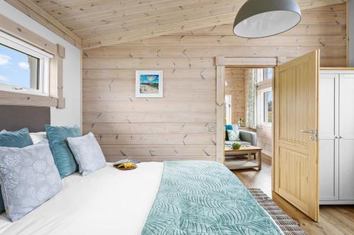a bedroom with a bed and a wooden wall at Middle Thorne, Great Field Lodges in Braunton