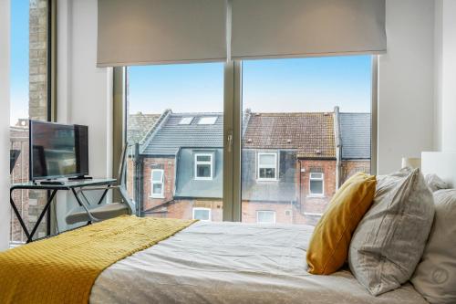 a bedroom with a bed and a large window at Utopian Apartments Kilburn in London