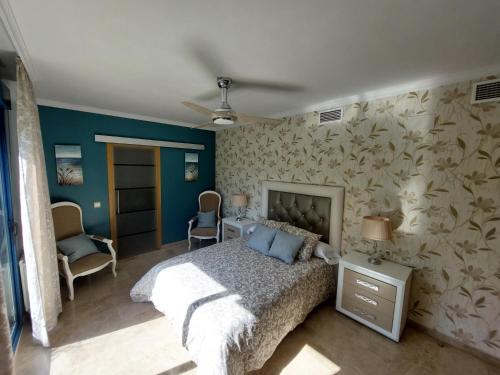 ein Schlafzimmer mit einem Bett und einer mit Blumen bedeckten Wand in der Unterkunft Atico Plata in Ronda