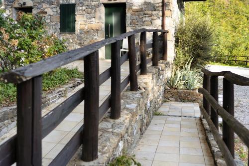 a wooden fence in front of a building with a walkway at Il Mulino - Appartamento Terra in Borzonasca