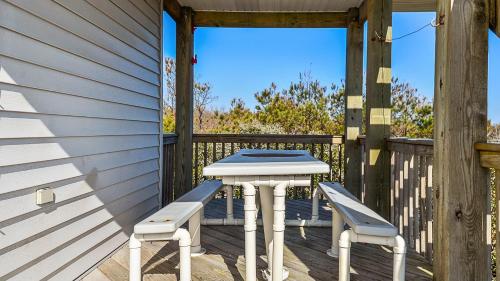 a table and two chairs on a wooden deck at Oceanside, 5 BRs, Wild Horses, 600 ft to Beach Access, 4wheel Drive Area, 4x2398, The T House in Knotts Island