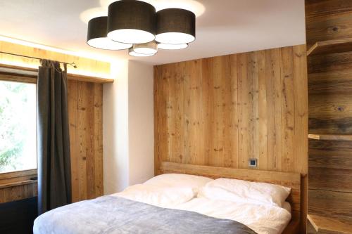 a bedroom with a wooden wall and a bed at Appartement Champex- Lac / La Cabouetta in Champex