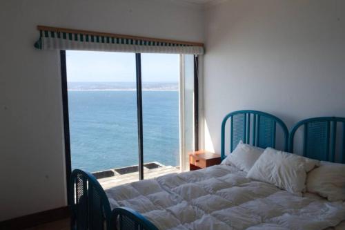a bedroom with a bed with a view of the ocean at Casa Cartagena en acantilado in Cartagena