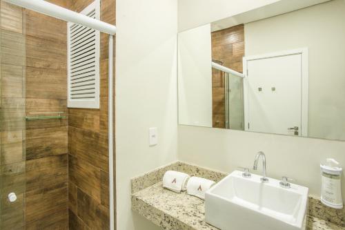 La salle de bains est pourvue d'un lavabo et d'un miroir. dans l'établissement Altitude Lodge Hotel, à Campos do Jordão
