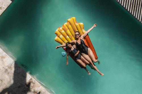 dos mujeres tumbadas en una balsa en el agua en Vilas de Montaña en San Martín de los Andes