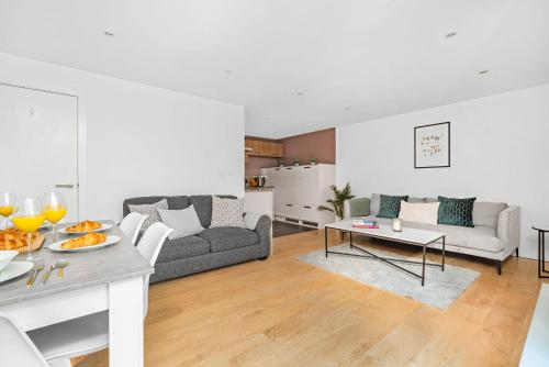 un soggiorno con divano e tavolo di King's Cross - 2BR with Terrace - CityApartmentStay a Londra