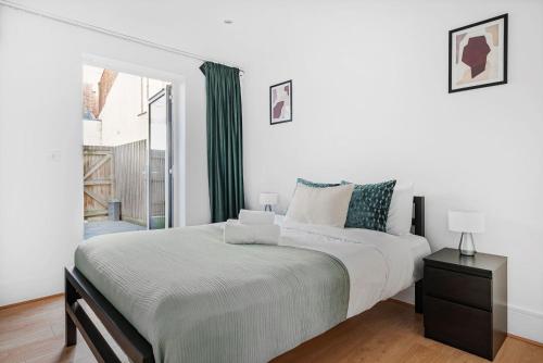 una camera bianca con un grande letto e una finestra di King's Cross - 2BR with Terrace - CityApartmentStay a Londra