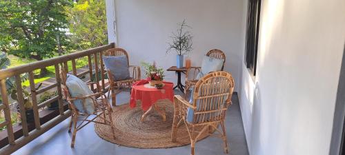eine Veranda mit einem Tisch und Stühlen auf dem Balkon in der Unterkunft Résidence au bout du Morne in Le Morne