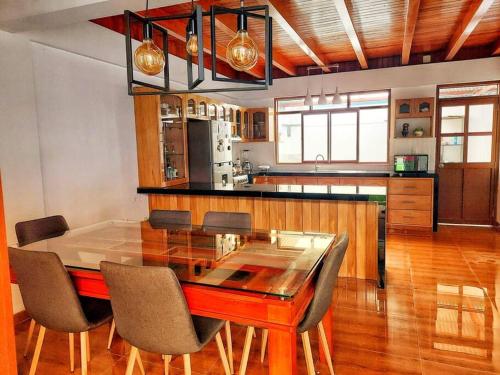 a kitchen with a dining room table and chairs at Casa Belgrado, te espera. in Oxapampa