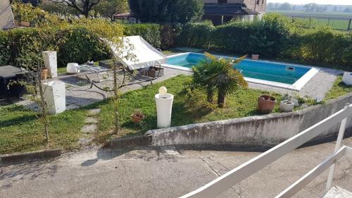une cour avec une piscine et une clôture blanche dans l'établissement Villa joy, à Calendasco